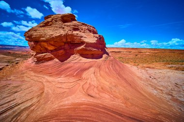Arizona çölünün yukarısında New Wave 'deki Beehive Patikası boyunca dramatik kumtaşı dalgaları yükseliyor. Parlak güneş ışığı altında canlı kırmızı kaya dokuları ve engin açık gökyüzü sergiliyor..