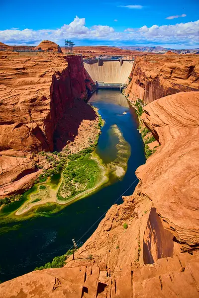 Glen Canyon Barajı 'nın Arizona' daki Colorado Nehri 'ni kaplayan havadan görüntüsü. Amerika' nın güneybatısındaki Page şehrinin yakınlarında gün ortası açık gökyüzü altında kırmızı kaya kanyonları ve canlı mavi su var.