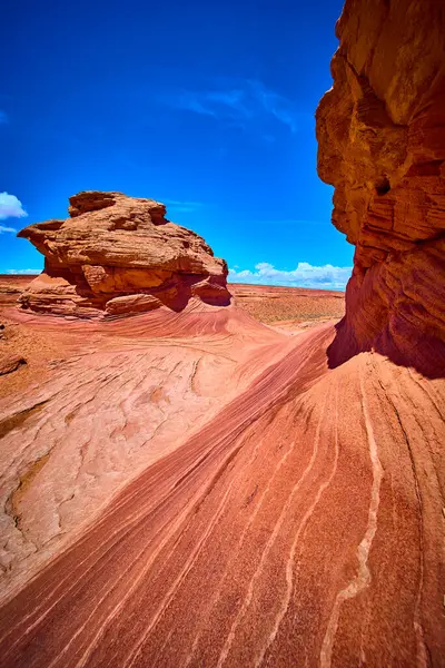 Canlı kırmızı kumtaşı dalgaları ve yontulmuş kaya oluşumları Arizona 'nın yakınlarındaki Arı Kovanı Yolu' nda dramatik bir mavi gökyüzünün altında Amerikan Güneybatı Çölü 'nün saf güzelliğini gözler önüne seriyor..