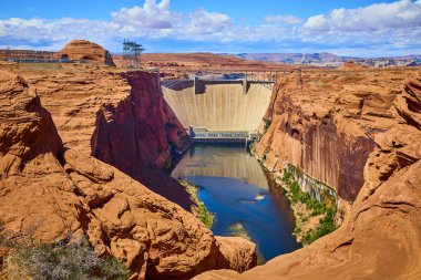 Colorado Nehri Arizona çölünde akarken Glen Canyon Barajı çarpan kızıl uçurumlar arasında yükseliyor. Amerika Birleşik Devletleri 'nin Page yakınlarındaki engebeli doğal güzelliğin ortasında etkileyici bir mühendislik sergiliyor..