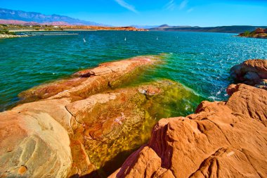 Canlı turkuaz sular Utah Kasırgası 'ndaki Sand Hollow Eyalet Parkı' nda çarpıcı kırmızı kumtaşıyla buluşur ve yaz macerası için mükemmel bir çöl gölü sahnesi sunar.