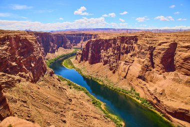 Colorado Nehri 'nin, Arizona Sayfası yakınlarındaki Glen Kanyonu' na doğru süzülen, canlı mavi su, kırmızı-turuncu kanyon duvarları ve Amerika 'nın güzelliğini gözler önüne seren dramatik bir gökyüzü.
