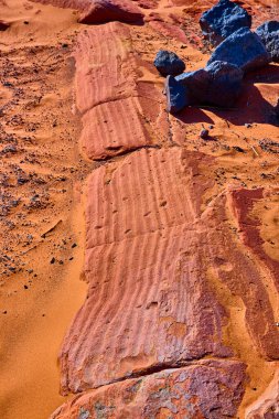 Sand Hollow Eyalet Parkı Utah çölündeki çizgili kırmızı kumtaşı ve karanlık volkanik kayaların canlı yakın çekimi çarpıcı dokuları ve Amerika 'nın güneybatısındaki doğal erozyonun güzelliğini gözler önüne seriyor.