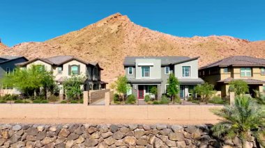 Henderson Nevada 'daki banliyö evlerinde, arka planda bereketli palmiye ağaçları ve dramatik çöl dağları ile birlikte Las Vegas Gölü' nün özünü yakalıyor..