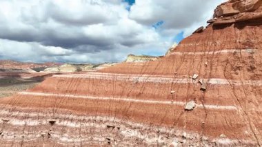 Kanab Utah yakınlarındaki Toadstool Hoodoo Patikası boyunca uzanan renkli katmanlı uçurumlar ve çarpıcı hudu oluşumları dramatik gökyüzü ve geniş Escalante çöl manzaralarıyla havada uçuşuyor..