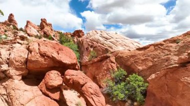 Büyük Escalante Vibes 'daki Kanab Utah yakınlarındaki canlı kırmızı kaya oluşumları ve kumtaşı tepelerinin üzerinden uçarak geçmek. Etrafı dinamik bir gökyüzü altında çöl bitkileriyle çevrili. Maceracı ve maceracı bir gökyüzü için.