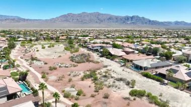 Las Vegas 'taki Silverstone Çiftlik Mahallesi' nin üzerindeki hava uçuşu ev evleri çöl manzaraları ve açık gün ışığı altında dağ manzaraları sergiliyor..