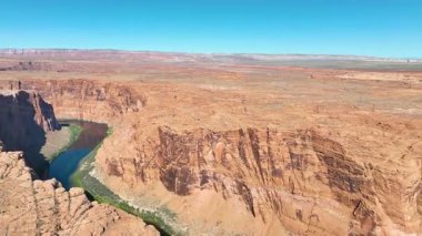 Glen Kanyonu ve Arizona 'daki Colorado Nehri' nin üzerinden Glen Canyon Barajı 'nın ve Powell Gölü' nün dramatik bir üstgeçidine doğru sürüklenen ve Page yakınlarındaki canlı çöl manzarasıyla çevrili olan