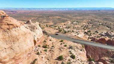 Kırmızı kaya dağlarının arasından geçen ve Arizona çölünün yakınındaki parlak, berrak gökyüzünün altındaki uzak mavi dağlarla birlikte uçarak seyahat macerasını ve doğal hayatı yakalıyor.