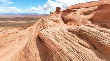 Arizona 'daki Page Shores Amfitiyatrosundaki kumtaşı tepelerinden ve çöl manzarasından çarpıcı kaya dokuları ve geniş manzaralarla uçarak macera ruhunu yakalıyor..