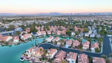 Aerial Fly Over: Las Vegas 'ta sakin bir banliyöde sakin bir göl ve yemyeşil bir arazi ile yaşamak. Uzakta ikonik şerit beliriyor, huzurlu titreşimleri kentsel cazibeyle harmanlıyor.