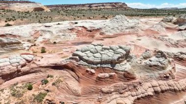 Vermilion Kayalıkları 'ndaki Ak Hücre üzerinde çekilen hava yayı Arizona parlak mavi gökyüzünün altında kıvrımlı kumtaşı oluşumlarını, canlı çöl renklerini ve geniş Mermer Kanyon arazisini vurguluyor..