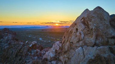 Whitney Pocket kaya oluşumları ve geniş Nevada çölü altın saatinde güneşin altında parıldıyor. Gold Butte Ulusal Anıtı günbatımı sükunetinin özünü yakalıyor.