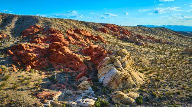 Altın güneş ışığı, Nevada Gold Butte Ulusal Anıtı 'ndaki Whitney Pocket' da kırmızı kaya oluşumlarını ve çöl arazisini aydınlatıyor.