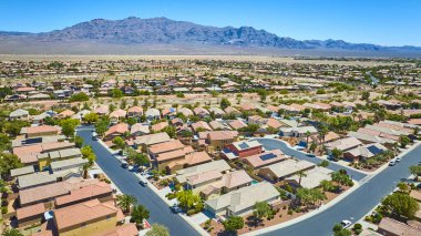 Temiz mavi gökyüzünün altında dramatik bir dağ sırasına kurulmuş, organize caddeleri ve yeşil alanları olan banliyö evleri geniş görüşlü.