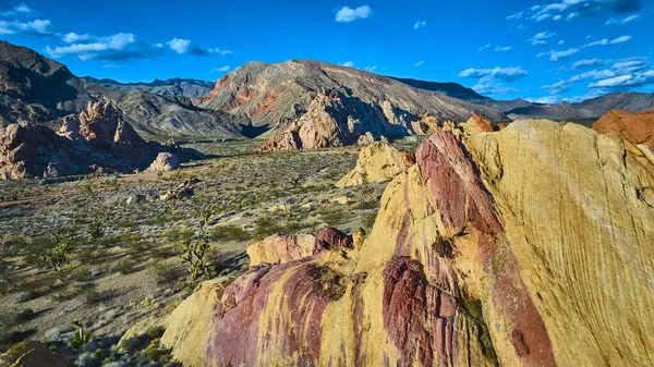 Nevada 'daki Altın Butte Ulusal Anıtı' nın canlı hava görüntüsü Whitney Pockets eşsiz kumtaşı oluşumları Joshua ağaçları ve açık mavi gökyüzü altındaki dağ arazisi