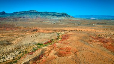Engebeli çöl arazisi sıradağları ve canlı açık gökyüzü içeren Altın Kalça Ulusal Anıtı 'nın geniş hava manzarası