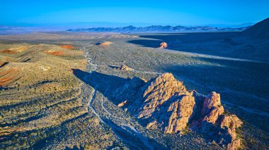 Güneşli kırmızı kaya oluşumları ve engebeli çöl arazisi. Altın Butte Ulusal Anıtı Nevada 'da. Altın saat, Whitney Pocket' in ve uzak dağların havadan görünüşü.