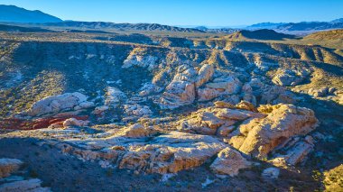 Nevada 'nın Gold Butte Ulusal Anıtı' ndaki Whitney Pocket 'da güneşli kumtaşı kayaları ve engebeli çöl arazisi altın saat boyunca havadan görüntülendi.