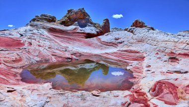 Canlı kumtaşı girdapları ve dramatik kaya oluşumları Vermilion Cliffs Ulusal Anıtı Arizona 'daki White Pocket' da Amerikan Güneybatısının vahşi güzelliğini gözler önüne seren sakin bir havuza yansıyor..