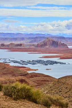 Powell Gölü 'nün panoramik manzarası yüzen yüzen yüzen evler ve yatlar Arizona Sayfası yakınlarındaki dramatik kırmızı kaya birikimleri arasında yer alıyor ve Güneybatı Amerika' nın çöl manzarasının güzelliğini ve macerasını yakalıyor.