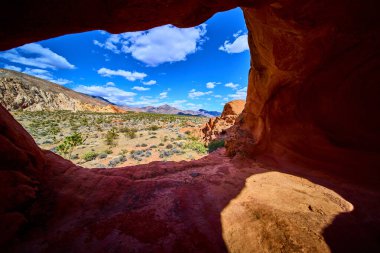 Gold Butte Ulusal Anıtı 'ndaki doğal kemer oluşumu Whitney Pocket Nevada' nın çöl manzarasını canlı kırmızı kaya ve geniş gökyüzü ile çerçeveler.