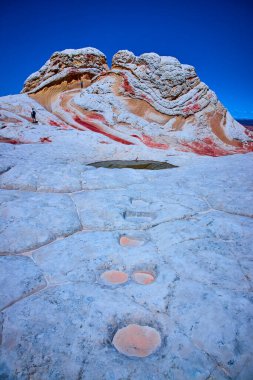 Maceracılar, Vermilion Cliffs Ulusal Anıtı Arizona 'da, Amerika' nın güneybatısının güzelliğini ve büyüklüğünü gösteren canlı mavi gökyüzünün altında dönen kumtaşı oluşumlarını keşfediyorlar.