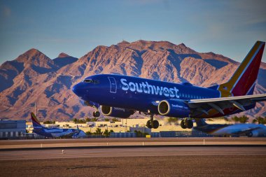 Açık bir günde Las Vegas havaalanından kalkmaya hazırlanan uçak ve arka planda Nevada dağları.