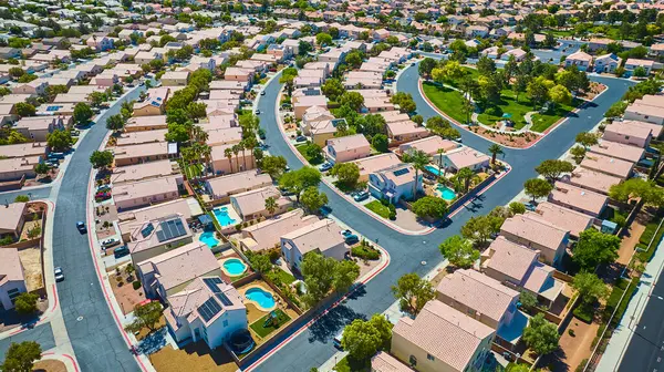 Cilalı banliyö sokakları güneşli bir Central Park 'ı çevreleyen bronz çatı evleri ve parlak gün ortası ışığı altında ışıl ışıl arka bahçe havuzlarıyla çevrili.