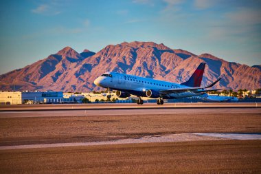 Ticari bir uçak Las Vegas havaalanından kalkmaya hazırlanıyor. Arka planda Nevada 'nın gökyüzü görünüyor..