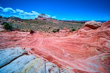 Vermilion Cliffs Ulusal Anıtı Arizona 'daki White Pocket' de parlak kırmızı ve beyaz kumtaşı kıvrımları uzak mesafelere sahip ve parlak mavi gökyüzü Amerikan Güneybatı Çölü 'nün vahşi güzelliğini yansıtıyor..