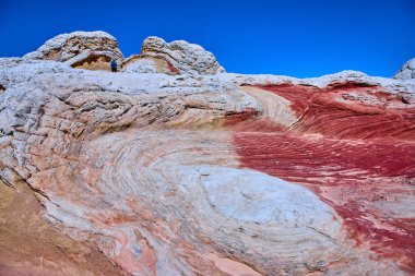 Arizona, Vermilion Kayalıkları 'ndaki White Pocket' da canlı bir kumtaşının üzerinde tek başına duran bir kaşif. Süpürücü desenler ve cesur renkler macera ve el değmemiş Amerikan vahşiliğinin güzelliğini anımsatıyor..