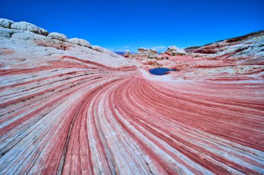 Dönen kumtaşı dalgaları ve canlı çizgiler Vermilion Cliffs Ulusal Anıtı Arizona 'da gerçeküstü bir manzara yaratıyor..