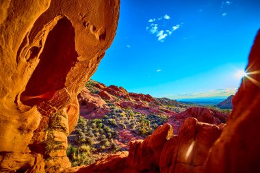 Güneş ışığı, Whitney Pocket 'deki kırmızı kumtaşı kemeri biçiminde akar. Nevada Ulusal Anıtı, engebeli araziyi ve canlı çöl renklerini aydınlatır.