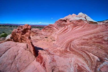 Canlı kırmızı ve beyaz kumtaşı dalgaları Arizona 'nın Vermilion Kayalıkları boyunca parlak mavi gökyüzü altında kıvrılarak Amerikan Güneybatı Çölü' nün eşsiz güzelliğini ve dramatik dokusunu gözler önüne seriyor.
