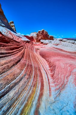 Kırmızı turuncu ve beyaz kumtaşı bantları Vermilion Cliffs Arizona 'daki White Pocket' da, parlak mavi gökyüzünün altında Mermer Kanyon 'un vahşi güzelliğini gözler önüne seriyor.