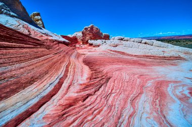 Canlı kırmızı ve beyaz kumtaşı girdapları Vermilion Cliffs Ulusal Anıtı Arizona 'daki White Pocket' da derin mavi gökyüzünün altında çarpıcı desenler oluşturur.