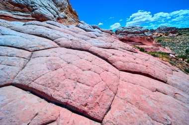 Vermilion Cliffs Ulusal Anıtı 'ndaki Beyaz Cep' in parlak kumtaşı dalgaları ve çatlamış dokuları Arizona parlak mavi gökyüzünün altında yükseliyor ve Amerikan Güneybatı Çölü 'nün saf güzelliğini gösteriyor.