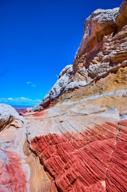 Vermilion Cliffs Ulusal Anıtı Arizona 'da parlak mavi gökyüzü altında yükselen turuncu ve beyaz kumtaşı girdapları Amerikan Güneybatısının dramatik güzelliğini yansıtıyor.