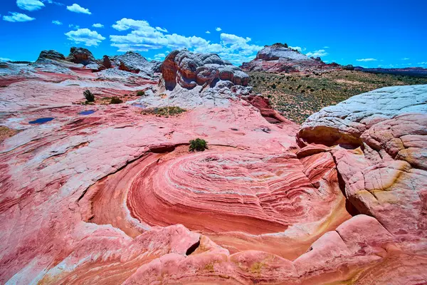 Vermilion Cliffs 'teki White Pocket' de dönen kumtaşı katmanları ve canlı çizgiler Arizona Ulusal Anıtı macera ve doğa temaları için açık mavi gökyüzü altında dramatik jeoloji sergiliyor
