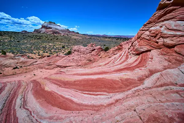 Vermilion Cliffs Ulusal Anıtı Arizona 'da, açık mavi gökyüzü altında macera yolculuğu ve jeoloji temaları için ideal bir yere sahip kırmızı ve beyaz kumtaşı girdapları.