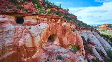 Utah 'taki Kanab Kum Mağaraları' nın havadan görünüşü kırmızı kumtaşı kayalıklarına çarpıyor. Canlı mağaralar ve engebeli çöl manzarası seyahat macerası ve doğa teması için mükemmel.