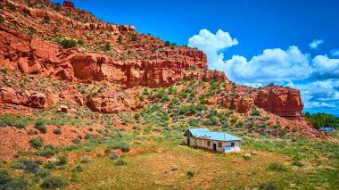 Kanab Utah 'taki dramatik kızıl kayalıkların altındaki verimli bir ovadaki terk edilmiş bir binanın havadan görünüşü canlı mavi gökyüzü yalnızlık macerası ve Amerika' nın güneybatısı teması için mükemmel.
