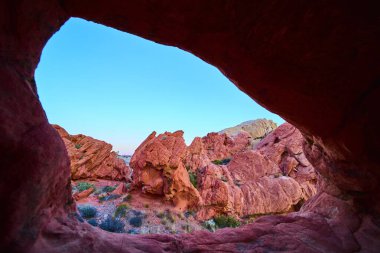 Doğal bir kemer düzeninden çarpıcı bir manzara. Kızıl kaya kayalıkları çöl bitki örtüsünü ve Nevada 'daki Gold Butte Ulusal Anıtı' nın ikonik arazisini vurguluyor.
