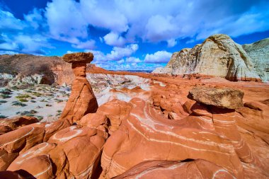 Grevci kabadayılar Kanab Utah yakınlarındaki Paria Rimrocks Toadstool Hoodoos 'dan yükseliyor. Canlı kumtaşı sütunları mavi gökyüzüne karşı duruyor ve dramatik bulutlar Güneybatının vahşi güzelliğini gösteriyor..