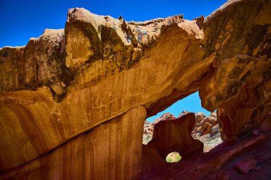 Kemer içinde bir kemer bulunan canlı kumtaşı kemeri Nevada 'daki Altın Göt Ulusal Anıtı' nda berrak bir mavi gökyüzünün altında eşsiz jeoloji ve çöl manzarasını ön plana çıkarıyor.