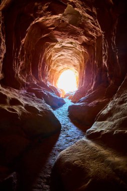 Güneş ışığı Kanab Utah yakınlarındaki Ejderha Mağarası 'na dökülüyor. Kaya duvarlarını vurguluyor ve Amerika' nın güneybatısında doğa keşfi ve ilham için davet edici bir yol çiziyor.