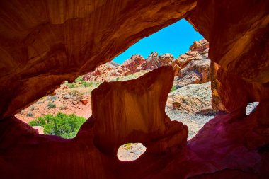 Whitney Pocket Nevada yakınlarındaki Gold Butte Ulusal Anıtı 'nda çarpıcı bir kemer oluşumu canlı kırmızı kayalara ve açık mavi gökyüzüne karşı bir kemer içinde dramatik bir kemer sergiliyor.