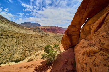 Güneşli kırmızı kaya kemeri Las Vegas yakınlarındaki Kızıl Kaya Kanyonu 'na bakar. Calico tepeleri ve engebeli dağlarla birlikte..