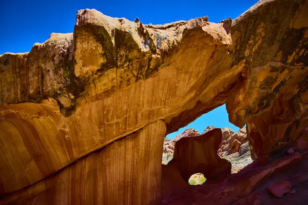 Kemer içinde bir kemer bulunan canlı kumtaşı kemeri Nevada 'daki Altın Göt Ulusal Anıtı' nda berrak bir mavi gökyüzünün altında eşsiz jeoloji ve çöl manzarasını ön plana çıkarıyor.